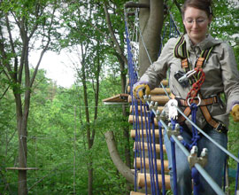 Person auf H&auml;ngebr&uuml;cke im Kletterwald